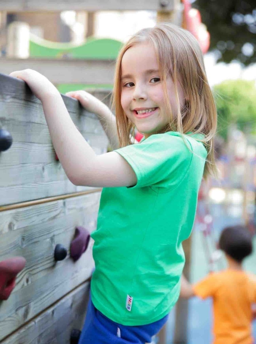 Girl wearing green organic cotton kids T-shirt - sustainable kidswear UK