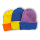 Three handmade reversible cotton beanies in different colour combinations: yellow blue, orange yellow, blue purple