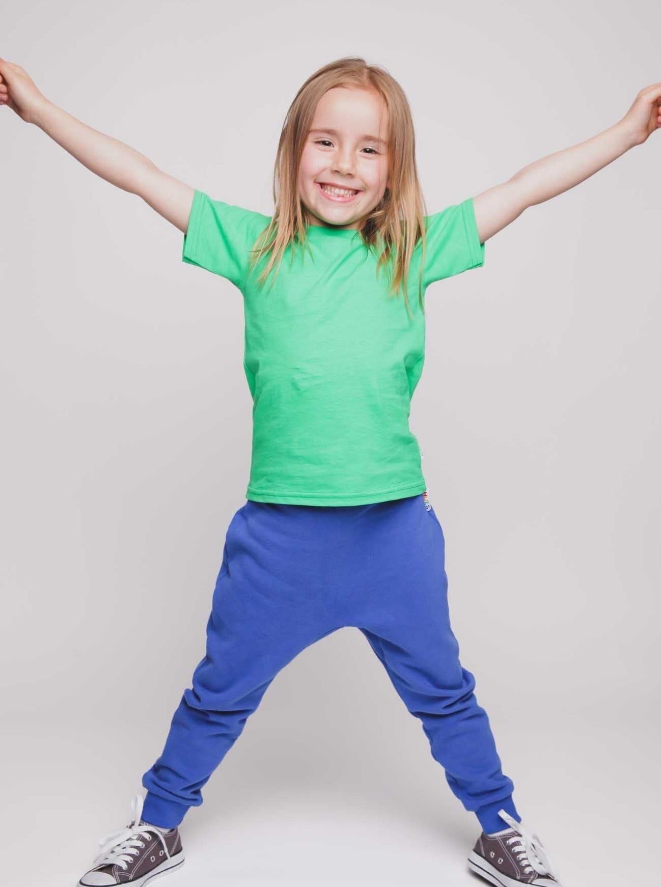 A girl wearing a green t-shirt and blue joggers - Hues Clothing