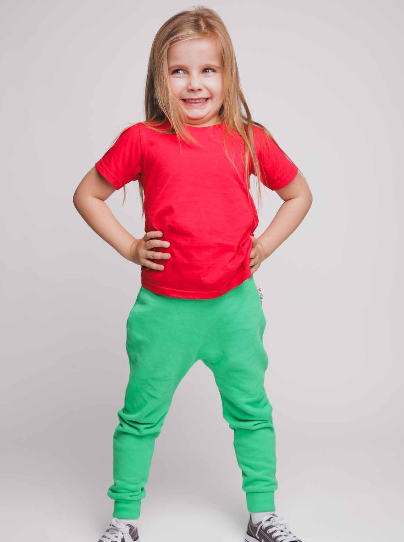 A girl wearing a red t-shirt and green joggers - Hues Clothing