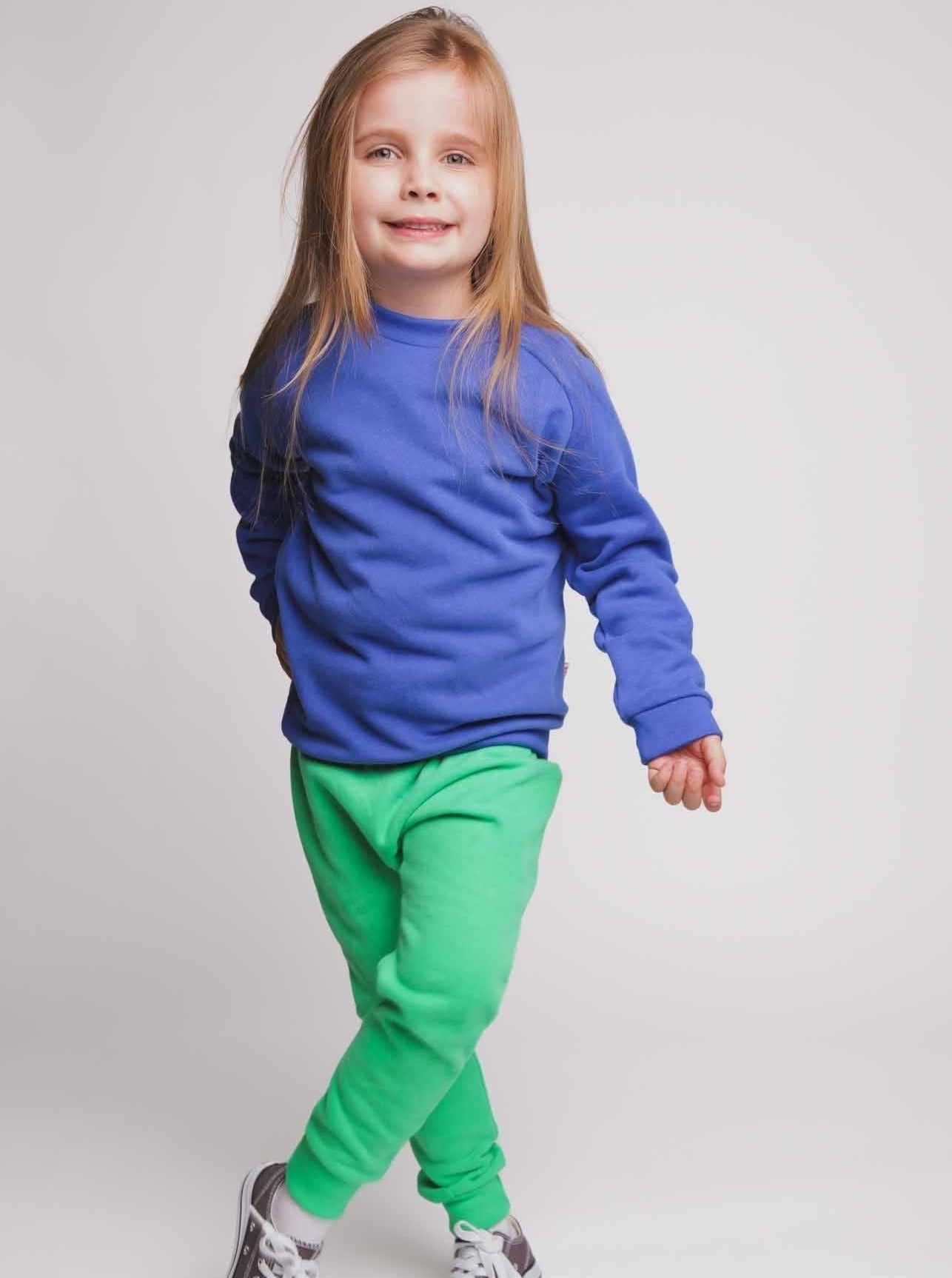 A girl wearing a blue jumper and green joggers - Hues Clothing