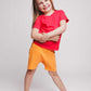A girl wearing a red t-shirt and orange shorts - Hues Clothing