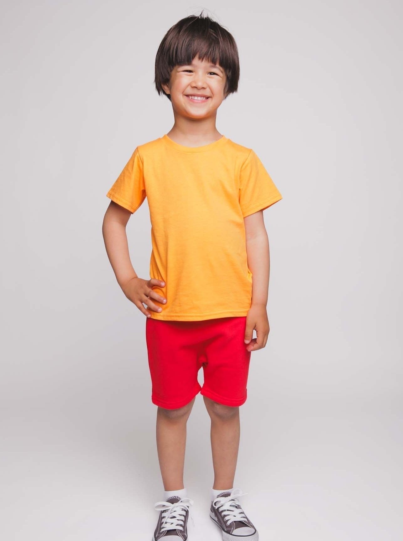 A boy with an orange shirt and red shorts - Hues Clothing