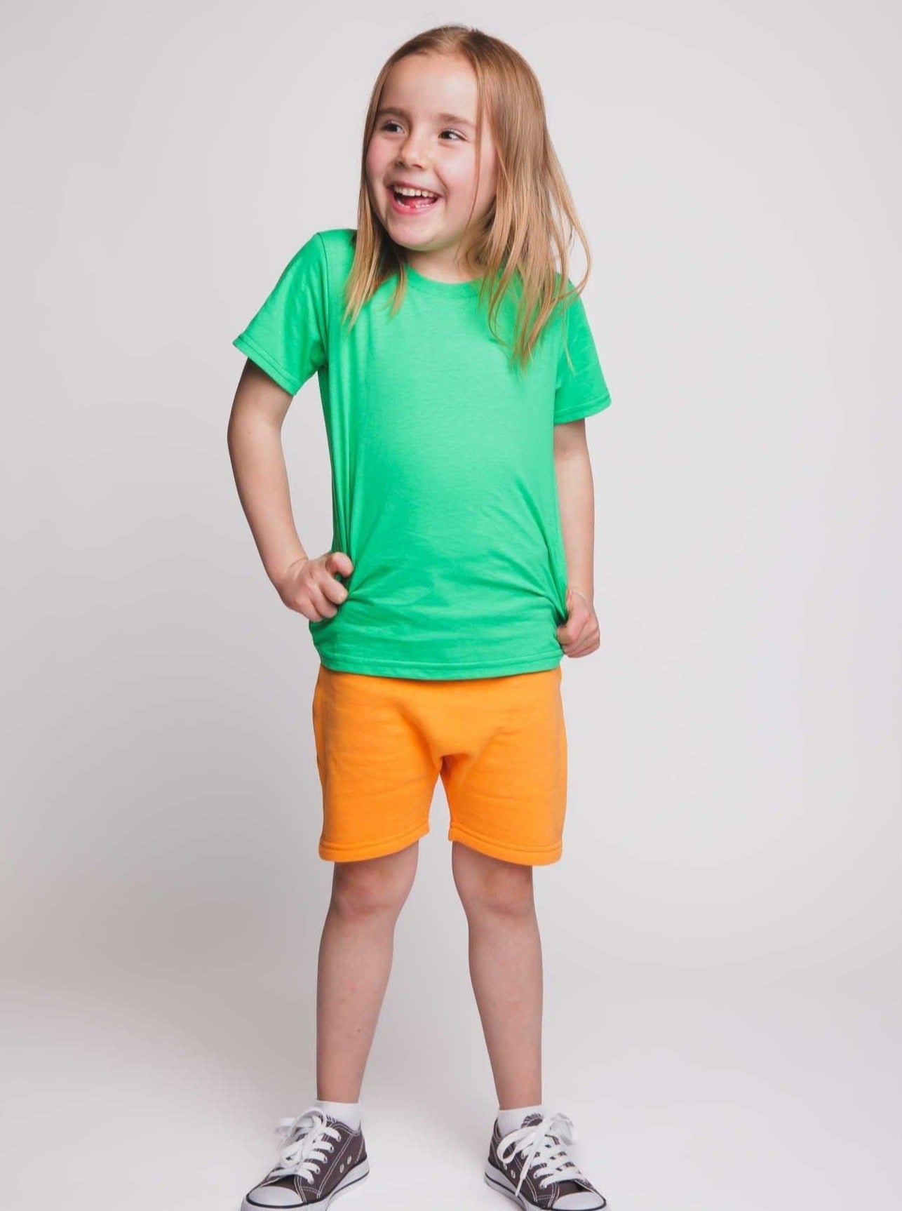 A girl wearing a green t-shirt and orange shorts - Hues Clothing