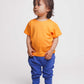 Toddler wearing an orange t-shirt and blue joggers - Hues Clothing