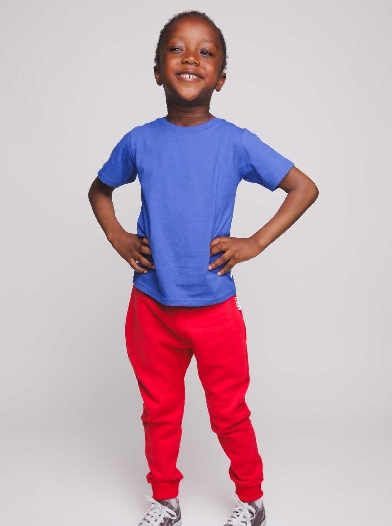 A boy wearing a blue t-shirt and red trousers - Hues Clothing