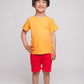 A boy wearing an orange t-shirt and red shorts - Hues Clothing